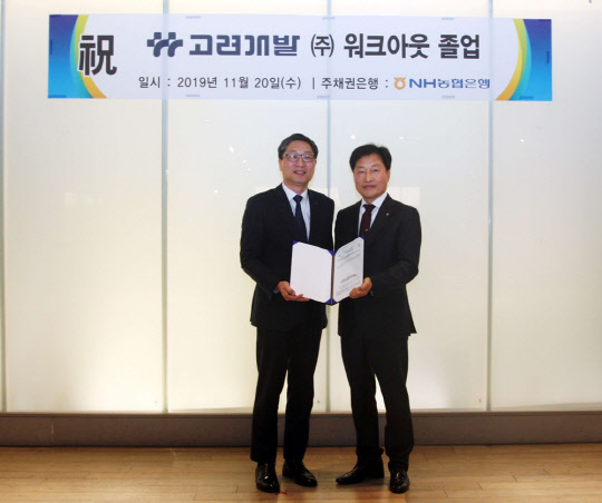 지난 20일 신라스테이 서대문점에서 열린 워크아웃 졸업 기념 행사에 참석한 곽수윤 고려개발 대표와 NH농협은행 박성일 부장이 채권금융기관 공동관리절차 종결 통지문을 교환하며 기념사진을 찍고 있다.<고려개발 제공>